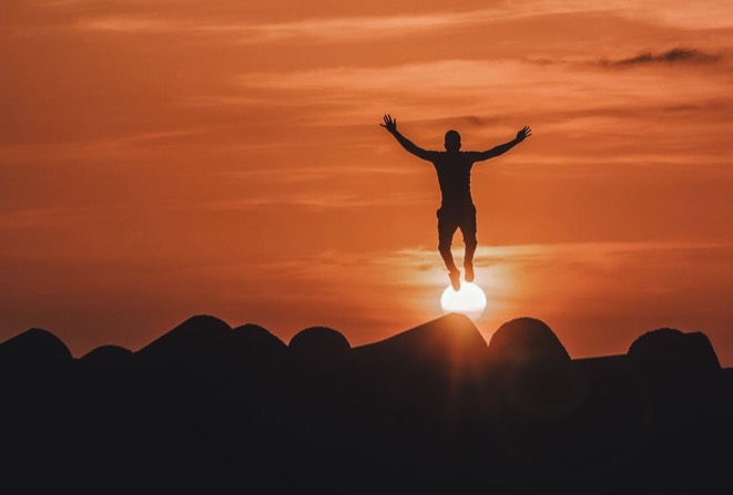 silouett av mann som hopper i solnedgangen